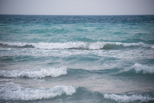 Peaceful view of ocean waves gently crashing on a calm sea day.